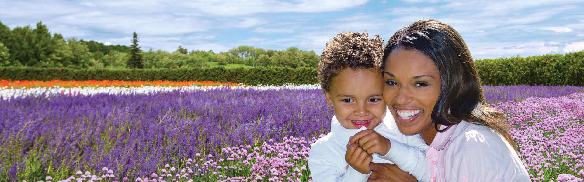 Mother holding her son in a field of flowers.